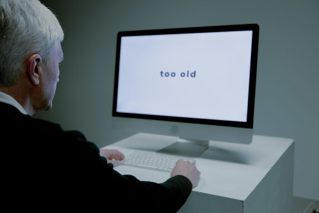 A senior man using the computer with keyboard